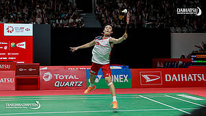Kento Momota mengembalikan shuttlecock.
