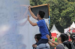 Para Pendukung Sedang Menulis Di Dinding Yang Bertemakan “Support Your Favourite Player Here”