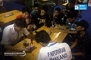 Beberapa Atlet Sedang Berkumpul Memainkan Game di Ponsel